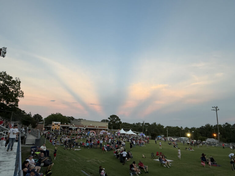 Crowd gathered on the recreation park lawn at dusk for the Fourth of July celebration